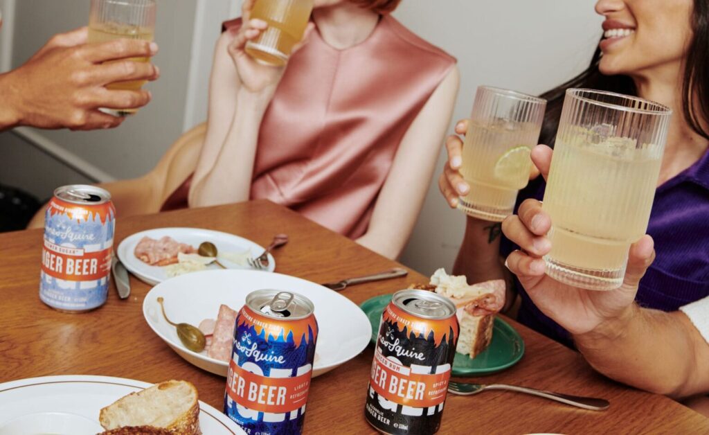 Friends enjoying food and cans of the James Squire Alcoholic Ginger Beer range